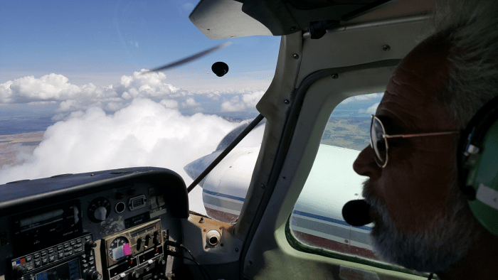 Multi Engine Instructor flying right seat over some clouds